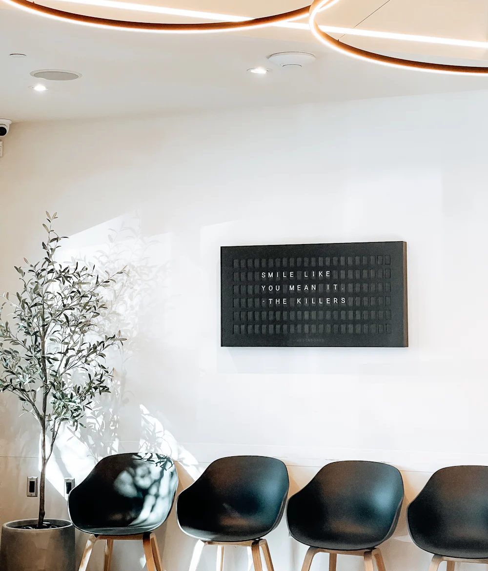 A calm, sunlit waiting room with a row of chairs